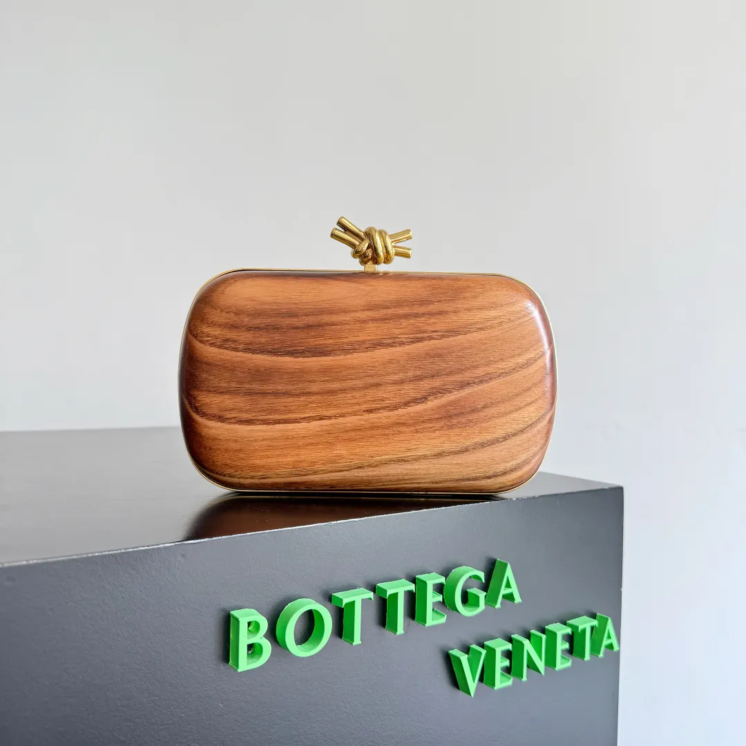 Batch 2720 BOTTEGA VENETA2025 new kont evening bag When the natural texture of wood meets the brass edge, the BV evening bag becomes a work of art in the fashion world. Every wood grain is a mark of time, delicate and unique. The brass metal buckle is embellished like stars, and opening it is full of ritual. It is the focus of the dinner party, and can easily store your exquisite small things. The warmth of wood and the cold and cool collision of metal tell the niche light luxury style in every gesture, allowing you to shine with a unique attitude in every feast. Style number: 804292 (717622) Color: maroon Size: 20.5*6*12.5cm